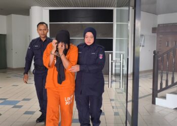 SUSPEK diiringi anggota polis ketika dibawa ke Mahkamah Majistret, Ayer Keroh, Melaka untuk permohonan reman.