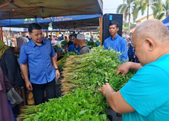 NOR Azhar Abdul Hamid (kiri) meninjau salah satu gerai sempena Program Jualan Khas Semarak Aidiladha Peringkat Negeri di Pasar Tani Jasin, Melaka. - UTUSAN/AMRAN ALI