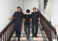 AHMAD Dzul Fiqar Ahmad Fardzil diiringi anggota polis keluar dari Mahkamah Sesyen, Ayer Keroh, Melaka selepas menghadapi lima pertuduhan berkaitan amang seksual fizikal. - UTUSAN/AMRAN ALI