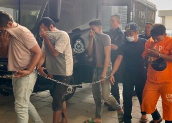 TERTUDUH (dua dari kanan) dibawa ke mahkamah bagi berdepan pertuduhan mengedar dadah berbahaya jenis syabu pada bulan lalu di Kompleks Mahkamah Kangar, Perlis, hari ini. - UTUSAN/ASYRAF MUHAMMAD