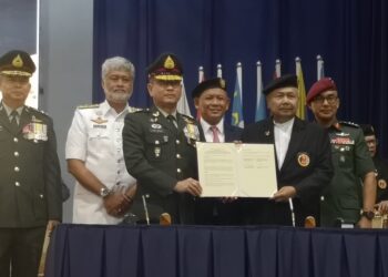 AMINUDDIN Harun (tengah) menyaksikan pertukaran dokumen di antara PVATM dan persatuan-persatuan veteran tentera ASEAN pada Majlis Sambutan Ulang Tahun PVATM Ke -103 di Seremban hari ini.
