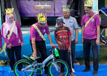 ZAINI Hussin (dua dari kiri) menyampaikan hadiah cabutan bertuah kepada penduduk Orang Asli di Kampung Pasir Linggi, Pos Lebir, Gua Musang, Kelantan semalam. – UTUSAN/AIMUNI TUAN LAH