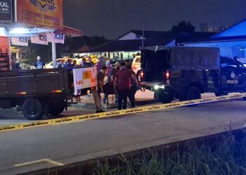 ANGGOTA polis mengangkat mayat mangsa di lokasi kejadian malam tadi. - UTUSAN / ISKANDAR SHAH MOHAMED
