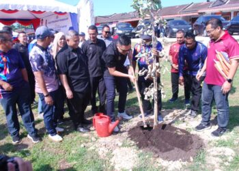 MUHAMAD Akmal Saleh menanam pokok sebagai simbolik merasmikan program WRUR DUN Bemban di Taman Kesang Damai, Jasin, Melaka. - UTUSAN/AMRAN MULUP