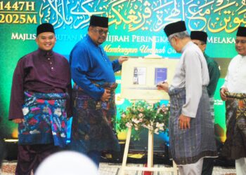 MOHD. ALI Mohd. Rustam menurunkan tandatangan ketika melancarkan ‘Buku Tatacara dan Panduan Pengurusan Perkahwinan, Perceraian dan Rujuk Orang Islam Negeri Melaka’ serta ‘Lafaz Taklik Dalam Braille’ di Masjid Al-Hakeem, Kampung Tehel, Melaka. - UTUSAN/AMRAN MULUP