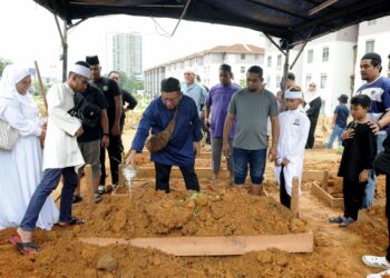 UNGKU SULAIMAN Ungku Aziz menyiram air di pusara Allahyarhamah Zaleha Hamid di Tanah Perkuburan Islam Kassim Noor, Kampung Sungai Danga, Johor Bahru.-UTUSAN/RAJA JAAFAR ALI