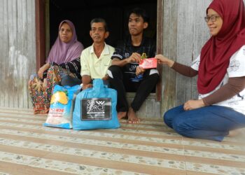 MOHAMAD Daniel Ikhwan Mamat (tiga dari kiri) menerima sumbangan dari Wan Zalilah Shafie di rumahnya di Kampung Kubang Chenok, Tok Uban, Pasir Mas, Kelantan.