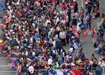 PENYOKONG PSG berkumpul ketika menunggu bas pasukan berarak di laluan Champs-Elysees di Paris.
