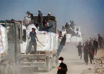 SUKARELAWAN Palestin mengawal trak bantuan yang memasuki Semenanjung Gaza melalui lintasan Zikim yang dikawal Israel, di barat Beit Lahia.-AFP