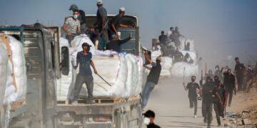 SUKARELAWAN Palestin mengawal trak bantuan yang memasuki Semenanjung Gaza melalui lintasan Zikim yang dikawal Israel, di barat Beit Lahia.-AFP