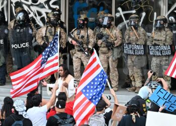 PENGAWAL Kebangsaan dan pegawai polis Persekutuan berkawal ketika sekumpulan penunjuk perasaan merusuh di hadapan Bangunan Persekutuan di Los Angeles, California. – AFP
