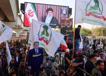 PENYOKONG kumpulan pro-Iran di Iraq memegang plakad imej Presiden Donald Trump semasa protes menyokong Iran di Baghdad, berhampiran kedutaan AS, pada Isnin lepas.- AFP