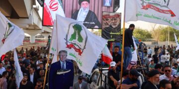 PENYOKONG kumpulan pro-Iran di Iraq memegang plakad imej Presiden Donald Trump semasa protes menyokong Iran di Baghdad, berhampiran kedutaan AS, pada Isnin lepas.- AFP