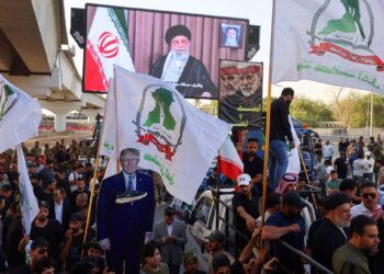 PENYOKONG kumpulan pro-Iran di Iraq memegang plakad imej Presiden Donald Trump semasa protes menyokong Iran di Baghdad, berhampiran kedutaan AS, pada Isnin lepas.- AFP