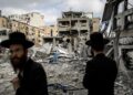 LELAKI Yahudi Ultra-Ortodoks memeriksa kerosakan di tapak serangan peluru berpandu Iran di Bnei Brak, timur Tel Aviv, semalam.- AFP