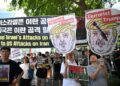 PENUNJUK perasaan memegang sepanduk memaparkan karikatur Presiden Donald Trump, semasa protes terhadap konflik Israel-Iran dan solidariti terhadap rakyat Gaza di Seoul, pada 22 Jun lepas.- AFP