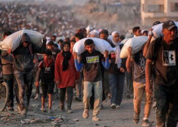 PENDUDUK Palestin membawa guni berisi tepung di laluan al-Rashid di barat Jabalia, Gaza. – AFP