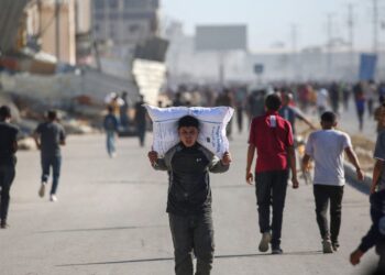 SEORANG kanak-kanak Palestin memikul guni tepung di atas bahunya ketika orang ramai menyerbu gudang Program Makanan Sedunia (WFP) di Deir el-Balah, tengah Gaza. – AFP