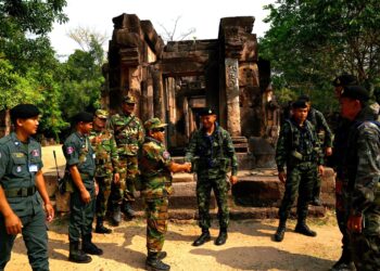 ASKAR Kemboja (tengah kiri) berjabat tangan dengan tentera Thailand (tengah kanan) di kuil Khmer purba, Prasat Ta Muen Thom, di sempadan Kemboja-Thai di wilayah Oddar Meanchey. – AFP
