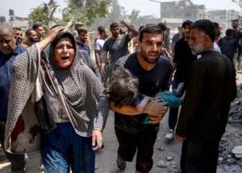 SEORANG lelaki mendukung kanak-kanak yang cedera dalam serangan Israel di kejiranan Saftawi, barat Jabalia, di Semenanjung Gaza.-AFP