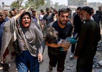 SEORANG lelaki mendukung kanak-kanak yang cedera dalam serangan Israel di kejiranan Saftawi, barat Jabalia, di Semenanjung Gaza.-AFP