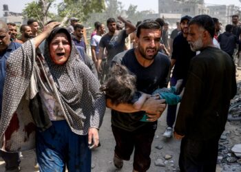 SEORANG lelaki mendukung kanak-kanak yang cedera dalam serangan Israel di kejiranan Saftawi, barat Jabalia, di Semenanjung Gaza.-AFP