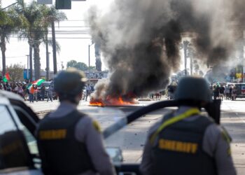 SEBUAH kereta terbakar ketika penguatkuasa undang-undang bertempur dengan penunjuk perasaan semasa protes berikutan operasi imigresen persekutuan, di kejiranan Compton di Los Angeles, California, kelmarin.- AFP