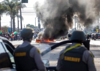 SEBUAH kereta terbakar ketika penguatkuasa undang-undang bertempur dengan penunjuk perasaan semasa protes berikutan operasi imigresen persekutuan, di kejiranan Compton di Los Angeles, California, kelmarin.- AFP