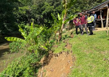 MOHD. Azmawi Fikri Abdul Ghani (kiri) melawat kawasan tebing sungai yang runtuh di Kampung Kuala Wook, Gua Musang, Kelantan. - UTUSAN/AIMUNI TUAN LAH
