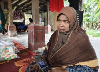 ZAINI Noh menunjukkan gambar kenangan yang dirakam bersama empat anaknya yang terkorban dalam nahas di Kilometer 7, Jalan Jerantut Feri-Maran, Pahang tengah malam tadi. - UTUSAN