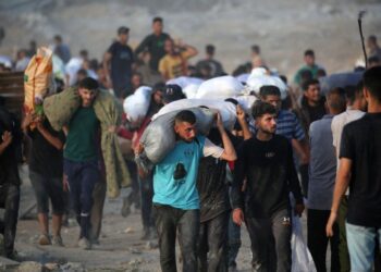 RAKYAT Palestin membawa bungkusan bantuan yang dikendalikan Yayasan Kemanusiaan Gaza (GHF) di jalan Salah al-Din berhampiran kem pelarian Nuseirat di tengah Gaza, Rabu lepas.- AFP