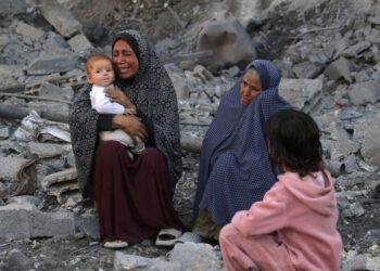 SEORANG wanita yang mendukung bayi menangis ketika penduduk Palestin memeriksa lokasi serangan Israel di Jabalia, tengah Semenanjung Gaza.-AFP
