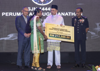 Anwar Ibrahim diiringi Razaruddin Husain dan Menteri Dalam Negeri, Datuk Seri Saifuddin Nasution menyampaikan pampasan kematian bernilai RM 212 500 kepada waris mendiang Sarjan S. Perumal, Helen Tracy Walter pada Mesyuarat Agung Perwakilan Tahunan Ke-90 Koperasi PDRM Berhad di Kuala Lumpur, semalam. - UTUSAN/AMIR KHALID