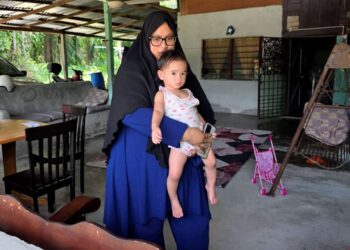 NORAZIAN Mohd. Joned bersama anaknya ketika ditemui di Kampung Sungai Itik, di Gopeng, Perak kelmarin. - UTUSAN/AIN SAFRE BIDIN