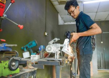 SHAIKH Ahmad Haikal Shaikh Rohmat mengasah pisau sembelihan yang dihasilkan menggunakan mesin khas bagi memenuhi permintaan tinggi pelanggan sempena Aidiladha di Jalan Padang Behor, Kangar, Perlis semalam. – UTUSAN/IZLIZAN OTHMAN