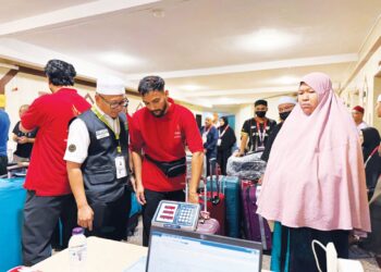 ABDUL Fattah  Mohd. Fasor (kiri) memantau proses daftar masuk di Abraj Al Janadriyah, Mekah semalam.