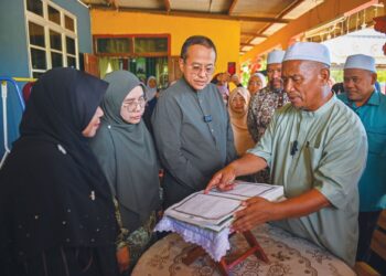AHMAD Samsuri Mokhtar melihat mushaf al-Quran tulisan tangan pelajar Universiti Pendidikan Sultan Idris (UPSI), Nurly Shahirah Azman, yang maut dalam kemalangan di Jalan Raya Timur-Barat (JRTB) berhampiran Tasik Banding, Gerik, 9 Jun lalu, di rumah arwah di Kampung Gong Pasir, Kerandang, Jertih, Besut, Terengganu. 
– UTUSAN/PUQTRA HAIRRY