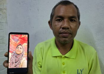 HAIROL  Jahim Mahmud menunjukkan gambar isterinya, Ellyza Ibrahim yang hilang hampir sebulan. - UTUSAN/AIN SAFRE BIDIN
