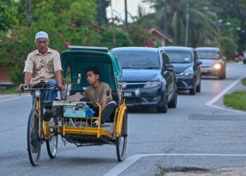 PENGAYUH beca, Mohd. Nasir Jusoh, 66, mengambil anaknya, Mohd. Safiuddin Mohd. Nasir,16, (kanan) pulang dari sekolah di Marang selepas seharian mencari rezeki di sekitar bandar Kuala Terengganu, semalam. - UTUSAN/PUQTRA HAIRRY