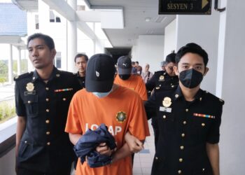 KEDUA-DUA suspek diiringi pegawai SPRM untuk permohonan reman di Mahkamah Majistret, Ayer Keroh, Melaka. - UTUSAN/MUHAMMAD SHAHIZAM TAZALI
