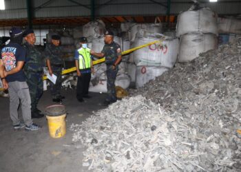 SHAHRUM Hashim (kanan) menunjukkan sisa e-waste yang dirampas dalam serbuan kilang haram di Kawasan Perindustrian Pengkalan di Lahat, Ipoh hari ini. - UTUSAN