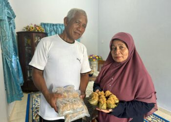 SALMAH Ismail dan Amran Hitam menunjukkan apam Johol yang dibuat di Kampung Balai Panjang Nuri, Negeri Sembilan. – UTUSAN/NOR SHAFIQAH MOHD. GHAZALI