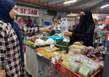 SEORANG pelanggan membeli santan segar di Pasar Siti Khadijah, Kota Bharu, Kelantan-UTUSAN/ ROSLIZA MOHAMED
