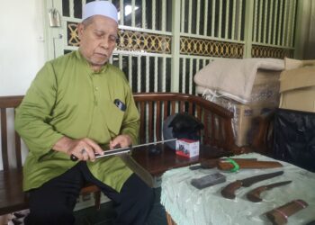 AZMI Ngah Thani mengasah parang yang akan digunakannya untuk menyembelih haiwan korban di Taman Desa Indah, Nilai, Negeri Sembilan. – UTUSAN/NUR SHARIEZA ISMAIL
