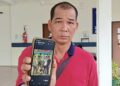 AZIZ Jaafar menunjukkan gambar empat anaknya yang meninggal dunia sebelum jenazah dibawa pulang ke Bota, Perak di perkarangan Unit Forensik Hospital Jerantut di Jerantut, Pahang.