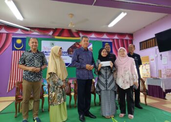 MOHAMAD Hasan menyampaikan sumbangan koperasi kepada anak ahli yang cemerlang sempena Majlis Perasmian Mesyuarat Agung Koperasi kali ke-52 Koperasi Kaum Ibu Penajes, di sini, hari ini. UTUSAN/NOR AINNA HAMZAH