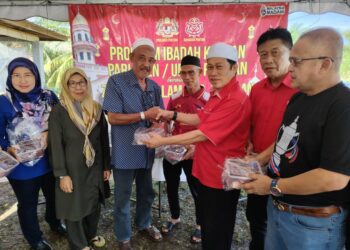AHMAD Maslan menyampaikan daging korban kepada penerima di Kampung Parit Stan, Benut, di Pontian Johor hari ini.