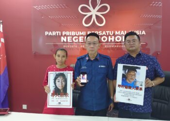 SOH SHUI PING (kiri) menunjukkan gambar anak perempuannya berusia 15 tahun yang didakwa dilarikan seorang lelaki dalam sidang akhbar di Masai, Johor Bahru.