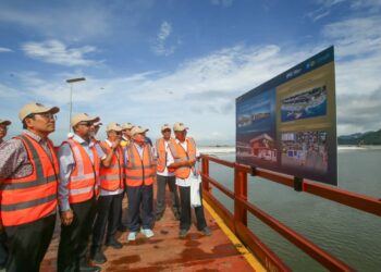 CHOW Kon Yeow (depan) ketika meninjau jambatan besi sementara yang menghubungkan daratan ke Pulau Silikon di Pulau Pinang.
