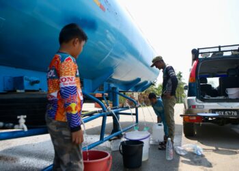 PENDUDUK mengangkut bekalan air bersih dari lori tangki yang diletakkan di hadapan masjid berikutan terputus bekalan sehingga menyukarkan urusan seharian di Kampung Pulau Tengah, Pendang, Kedah. – UTUSAN/ SHAHIR NOORDIN